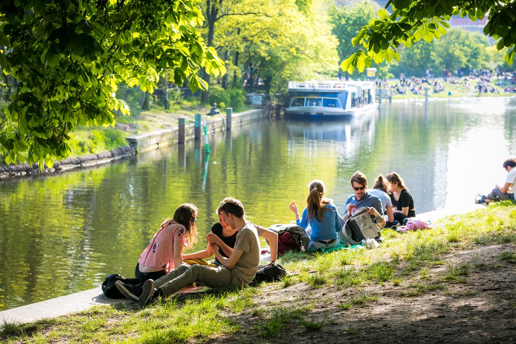 Berlin, Germany - May 12, 2017: Crowded banks of the Landwehr Canal in Berlin, Germany, young people enjoying the sun near the water.